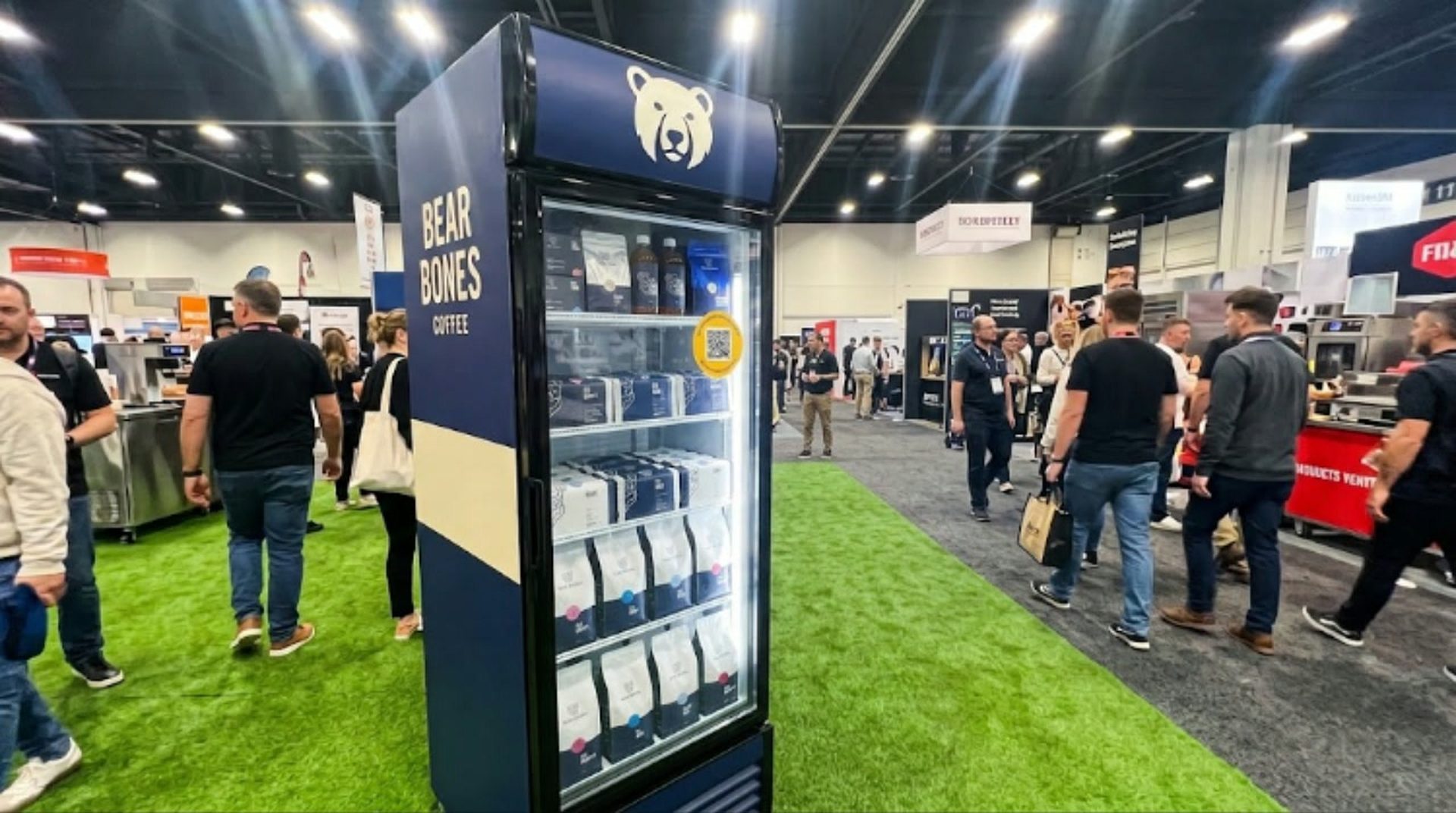 A Perkd cabinet standing on the expo floor, with visitors walking past it.